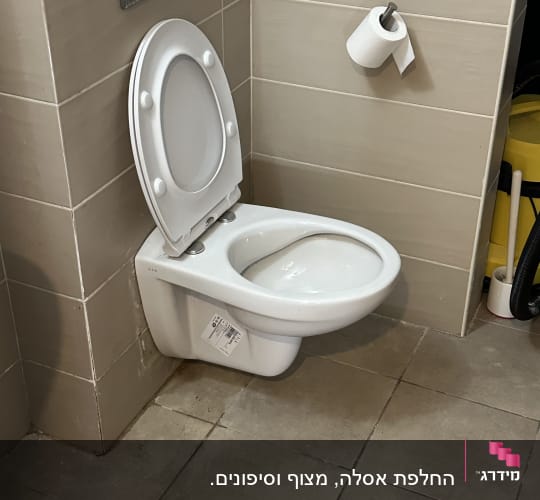 אסלה מותקנת עם מכסה פתוח ונייר טואלט על הקיר